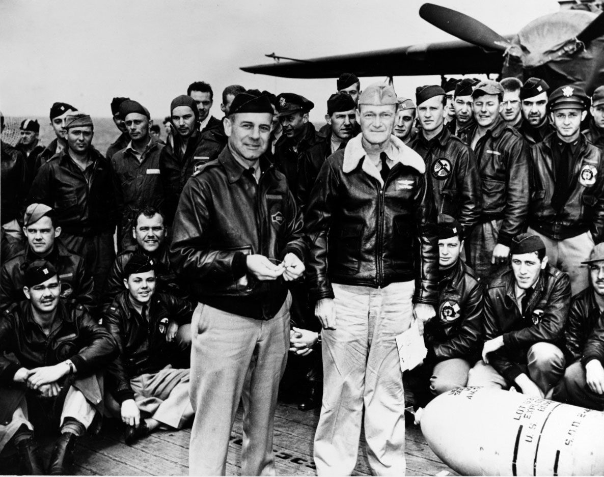 Le LCL James H. Doolittle et le CV Marc A. Mitscher, commandant l’USS Hornet (CV-8) posent avec des membres d’équipage de l’USAAF – Photo Ⓒ U.S. Naval History and Heritage Command. -