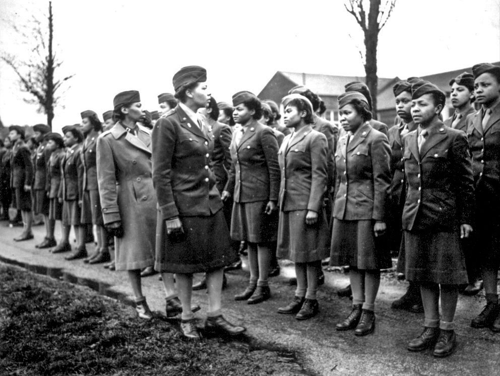 Women's Army Corps Maj. Charity Adams, 6888th Central Postal Directory Battalion commander, and Army Capt. Abbie Noel Campbell, 6888th CPD executive officer, inspect the first soldiers from the unit to arrive in England, Feb. 15, 1945. The only all-African-American Women's Army Corps unit sent to Europe during World War II, the 6888th was responsible for clearing years' worth of backlogged mail in both England and France. National Archives photo. -