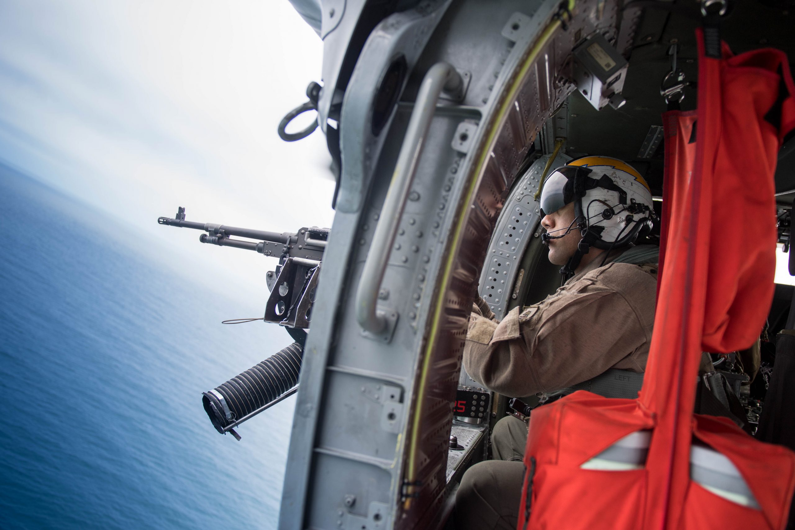 PACIFIC OCEAN (May 7, 2018) Naval Air Crewman (Helicopter) 2nd Class Juan Morabarajas, from Oakland, Calif., mans a .50-caliber machine gun inside an MH-60S Sea Hawk helicopter assigned to the Chargers of Helicopter Sea Combat Squadron (HSC) 14. The aircraft carrier USS John C. Stennis (CVN 74) is underway with the ships and squadrons of Carrier Strike Group (CSG) 3 conducting group sail training in preparation for its next scheduled deployment. U.S. Navy photo by Mass Communication Specialist 3rd Class Cole C. Pielop. -