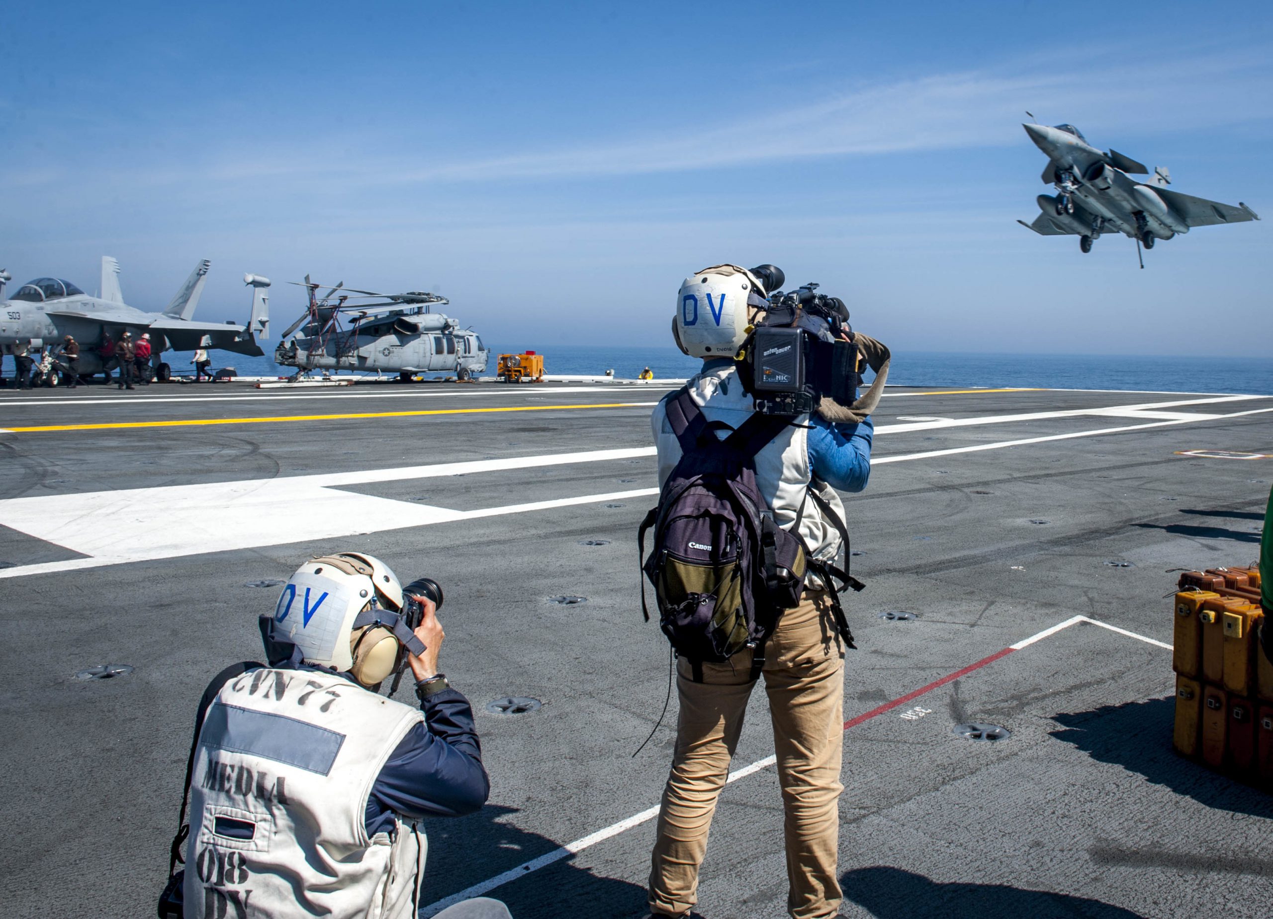 French media gather imagery and footage as a Rafale French navy aircraft attached to prepares to launch during flight operations aboard the aircraft carrier USS George H.W. Bush in the Atlantic Ocean, May 11, 2018. The carrier is conducting air wing exercises with the French navy to strengthen partnerships and deepen interoperability between the two nations' naval forces. Navy photo by Petty Officer 3rd Class Brooke Macchietto. -