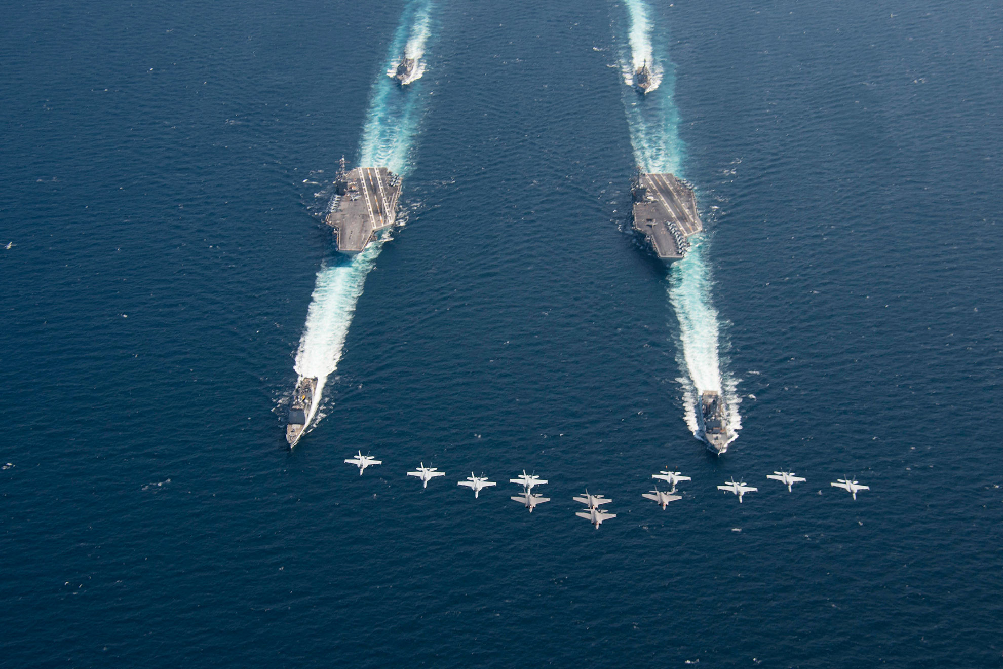 Atlantic Ocean (Aug. 30, 2018) Aircraft from the Freedom Fighters of Carrier Air Wing 7 fly in formation above the Nimitz-class aircraft carriers USS Abraham Lincoln (CVN 72) and USS Harry S. Truman (CVN 75); the Arleigh Burke-class guided-missile destroyer USS Mason (DDG 87) from Destroyer Squadron 2; the Arleigh Burke-class guided-missile destroyers USS Forrest Sherman (DDG 98) and USS Arleigh Burke (DDG 51) from Destroyer Squadron 28; and the Ticonderoga-class guided-missile cruiser USS Normandy (CG 60) while transiting the Atlantic Ocean. The USS Abraham Lincoln Carrier Strike Group and USS Harry S. Truman Carrier Strike Group are participating in dual-carrier sustainment and qualification operations in the Atlantic Ocean -- U.S. Navy photo by MCS1 Brian M. Brooks. -