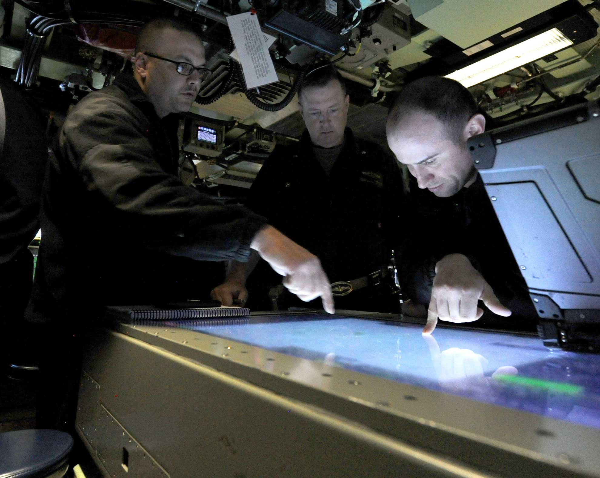 Atlantic Ocean (June 24, 2018) Cmdr. Jesse Zimbauer, center, commanding officer of the Virginia-class fast attack submarine Pre-Commissioning Unit (PCU) Indiana (SSN 789) observes the review of navigational charts while underway. Indiana is the 16th Virginia-class fast attack submarine and is scheduled to be commissioned Sept. 29, 2018 -- U.S. Navy photo by Chief MCS Darryl Wood. -