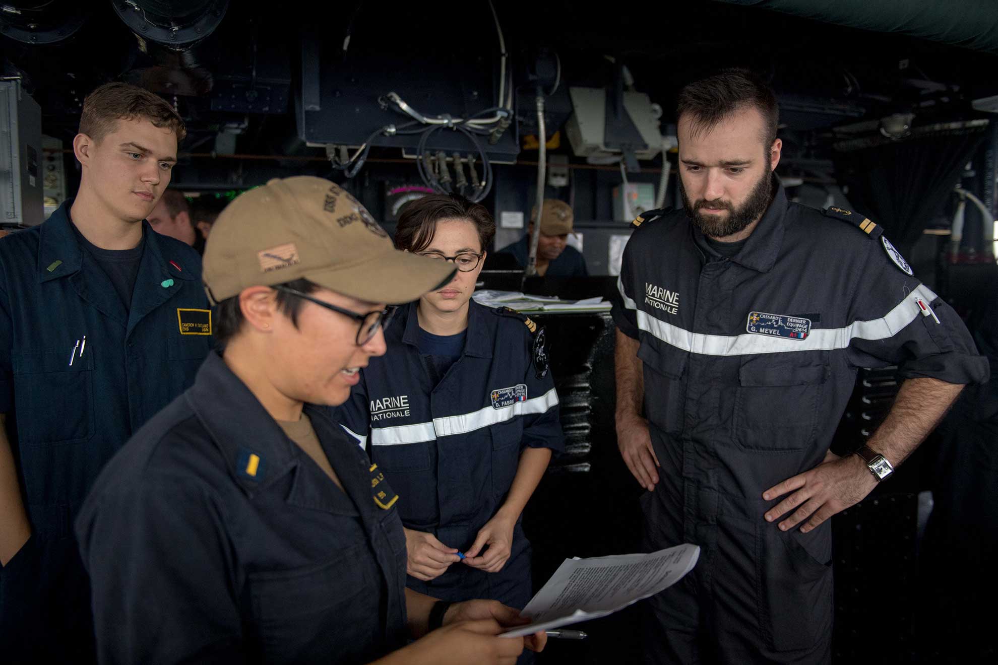 Arabian Sea (Dec. 14, 2018) U.S. Navy Ensign Alison Flynn, from Troutdale, Oregon, speaks with French navy officers from the French navy F70AA-class air defense destroyer FS Cassard (D 614) aboard the guided-missile destroyer USS Stockdale (DDG 106) during anti-submarine warfare exercise SHAREM 195 in the Arabian Sea, Dec. 14, 2018. Stockdale is deployed to the U.S. 5th Fleet area of operations in support of naval operations to ensure maritime stability and security in the Central Region, connecting the Mediterranean and the Pacific through the western Indian Ocean and three strategic choke points -- U.S. Navy photo by MCS2 Abigayle Lutz. -
