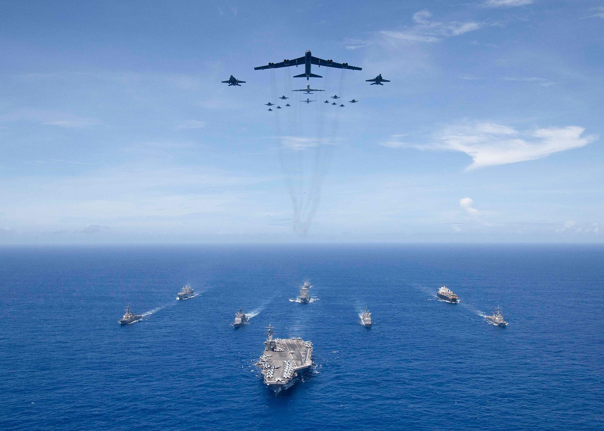 Philippine Sea (Sept. 17, 2018) The aircraft carrier USS Ronald Reagan (CVN 76) leads a formation of Carrier Strike Group (CSG) 5 ships as U.S. Air Force B-52 Stratofortress aircraft and U.S. Navy F/A-18 Hornets pass overhead for a photo exercise during Valiant Shield 2018. The biennial, U.S. only, field-training exercise focuses on integration of joint training among the U.S. Navy, Air Force and Marine Corps. This is the seventh exercise in the Valiant Shield series that began in 2006 --U.S. Navy photo by MCS3 Erwin Miciano. -