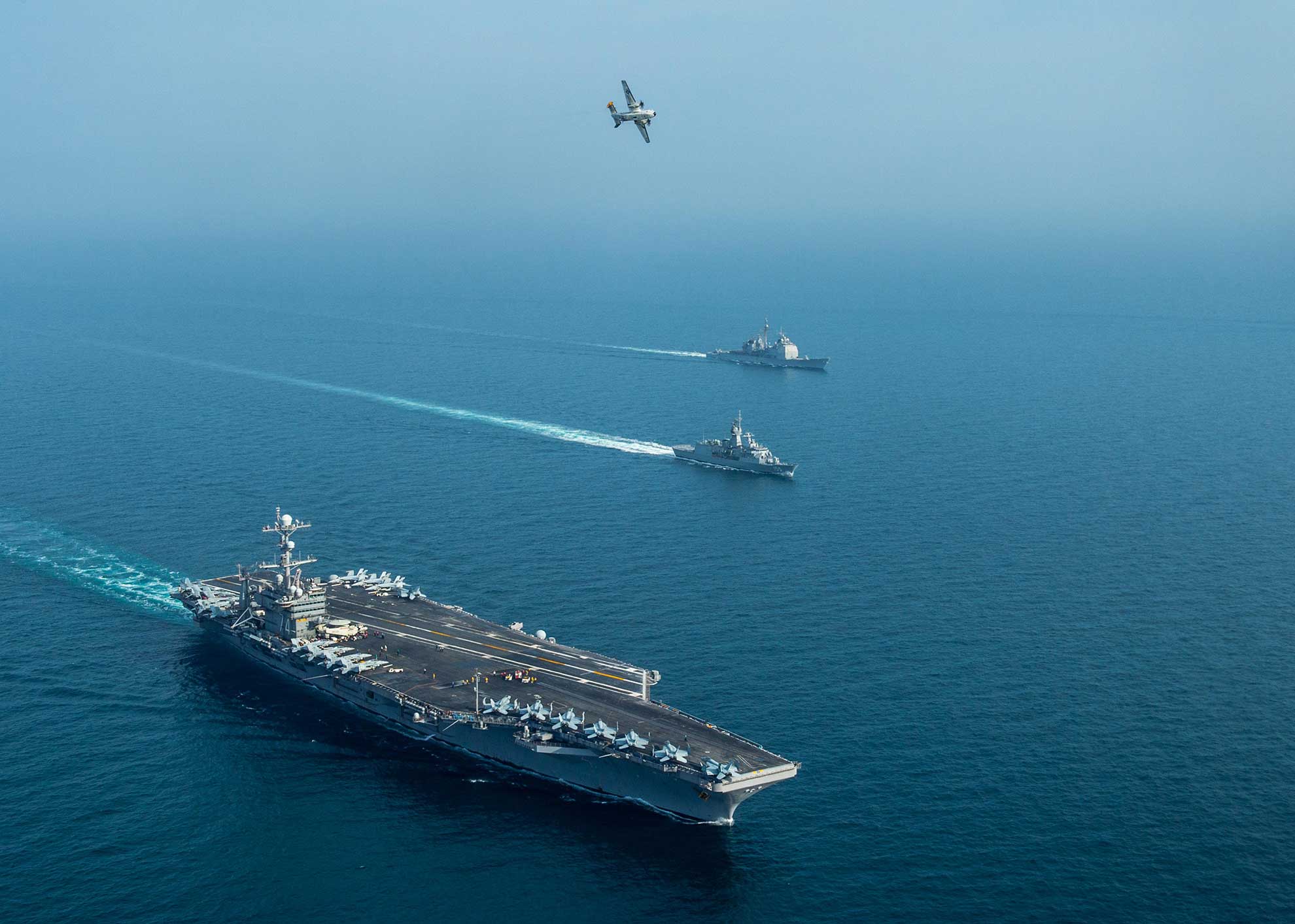 Arabian Gulf (Jan. 16, 2019) The aircraft carrier USS John C. Stennis (CVN 74),left, and the Royal Australian Navy frigate HMAS Ballarat (FFH 155), middle, and the guided-missile cruiser USS Mobile Bay (CG 53), sail in formation as a C-2A Greyhound, assigned to Fleet Logistics Combat Support Squadron (VRC) 30, detachment 4, conducts a flyover in the Arabian Gulf, Jan. 16, 2019, during exercise Intrepid Sentinel -- U.S. Navy photo by MCS3 Jake Greenberg. -