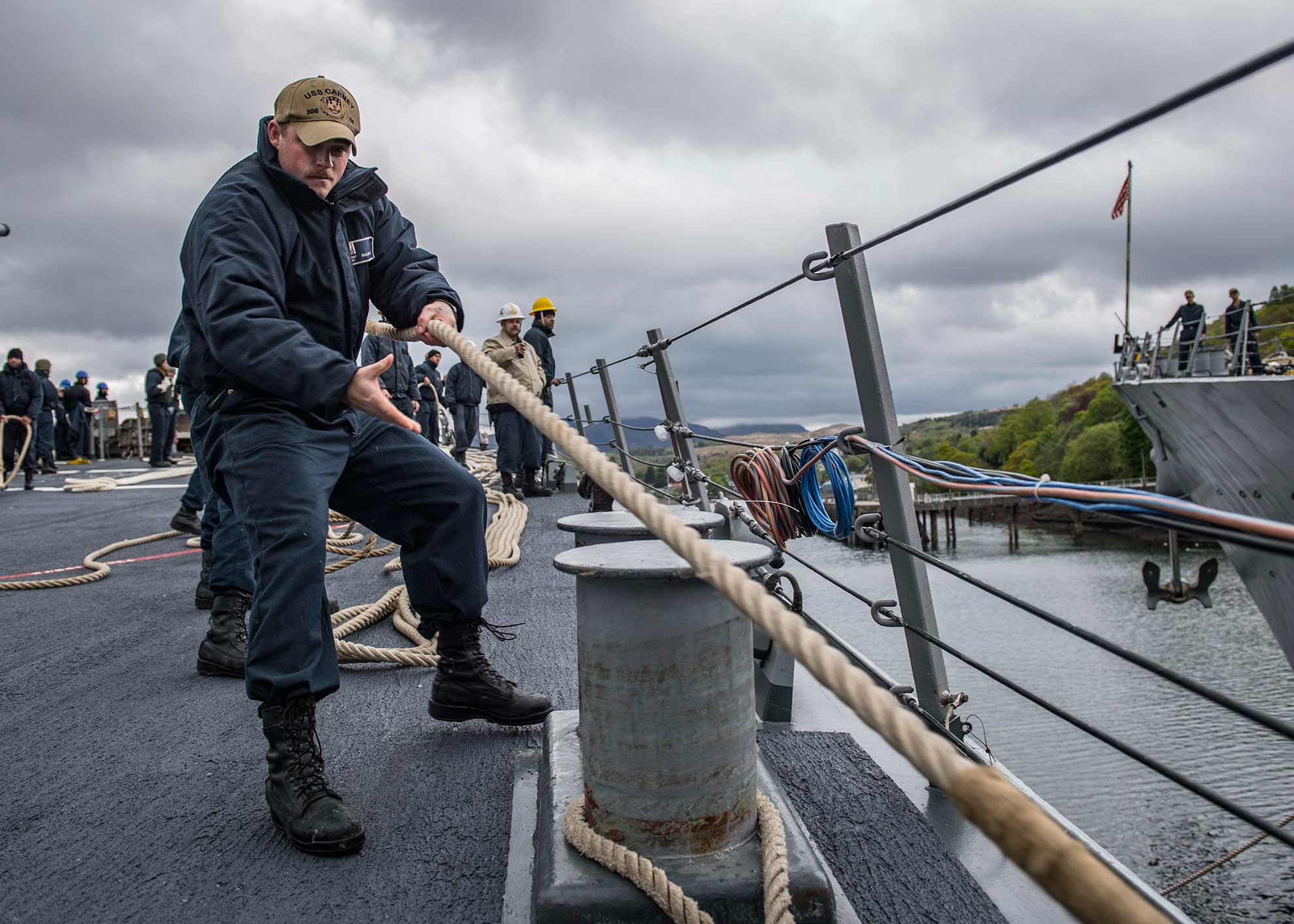 Scotland (May 8, 2019) Boatswain's Mate Seaman Timothy Mallon, from Philadelphia, heaves in a mooring line after the Arleigh Burke-class guided-missile destroyer USS Carney (DDG 64) gets underway from Faslane, Scotland, to participate in Formidable Shield 19, May 8, 2019. Formidable Shield is designed to improve allied interoperability in a live-fire integrated air and missile defense environment, using NATO command and control reporting structures. (U.S. Navy photo by Mass Communication Specialist 1st Class Fred Gray IV. -