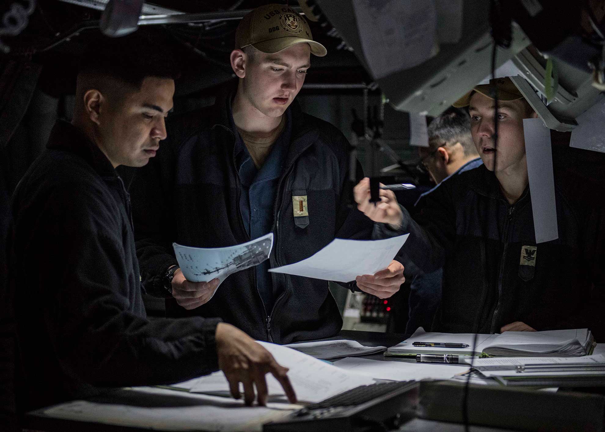 Atlantic Ocean (May 8, 2019) Ensign John Penner, center, from Arlington Heights, Illinois, receives combat information center watch officer training from Operations Specialist 1st Class Joseph Yambao, left, from Beaverton, Oregon, and Operations Specialist 2nd Class Taylor Seleck, from Cedar Rapids, Iowa, aboard the Arleigh Burke-class guided-missile destroyer USS Carney (DDG 64) during Formidable Shield 19, May 8, 2019. Formidable Shield is designed to improve allied interoperability in a live-fire integrated air and missile defense environment, using NATO command and control reporting structures. (U.S. Navy photo by Mass Communication Specialist 1st Class Fred Gray IV. -