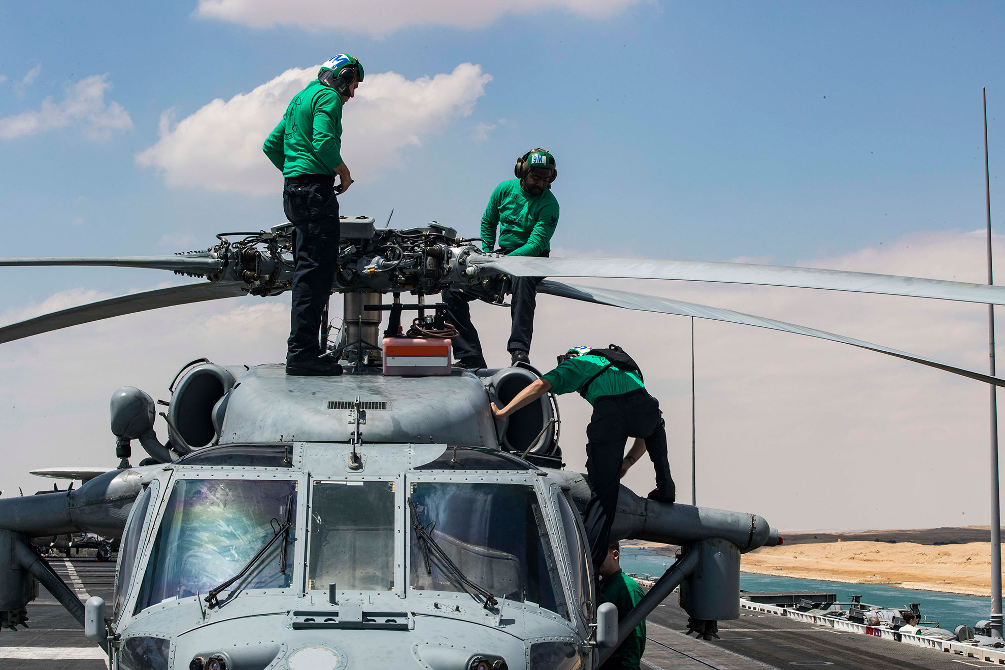 Suez Canal (May 9, 2019) Sailors perform maintenance on an MH-60S Sea Hawk helicopter from the "Nightdippers" of Helicopter Sea Combat Squadron (HSC) 5 on the flight deck of the Nimitz-class aircraft carrier USS Abraham Lincoln (CVN 72) as the ship transits the Suez Canal. The Abraham Lincoln Carrier Strike Group (ABECSG) is deployed to the U.S. Central Command area of responsibility in order to defend American forces and interests in the region. With Abraham Lincoln as the flagship, deployed strike group assets include staffs, ships and aircraft of Carrier Strike Group 12 (CSG 12), Destroyer Squadron 2 (DESRON 2), USS Leyte Gulf (CG 55) and Carrier Air Wing 7 (CVW 7); as well as the Spanish navy lvaro de Bazan-class frigate ESPS Mendez Nñez (F 104) -- U.S. Navy photo by MCS 2nd Class Zachary Hale. -