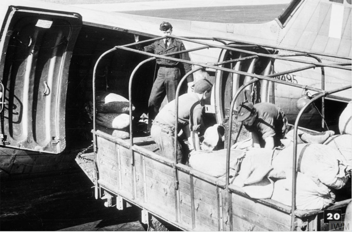 German civilians unload supplies from a Douglas Dakota of Royal Air Force Transport Command at RAF Gatow during the Berlin Airlift, 1948. RAF Photo © IWM (MH 30692). -
