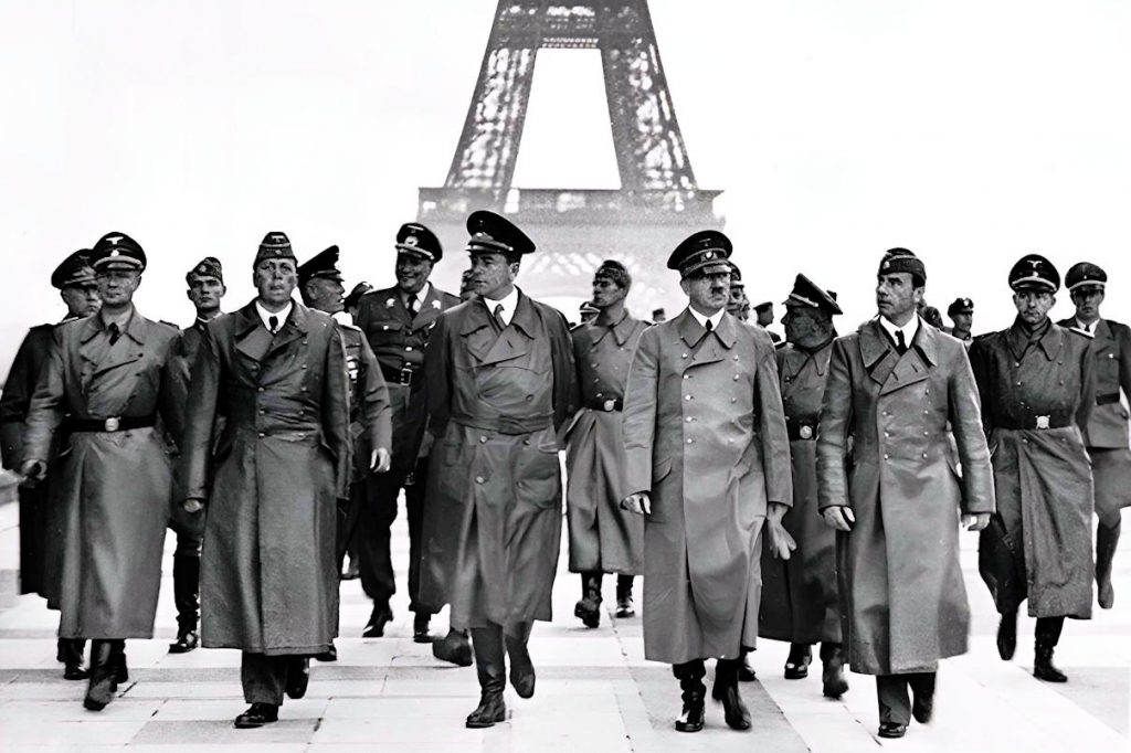 - Adolf Hitler a Paric1as Hitler visite Paris au petit matin, sa seule visite dans la capitale française — dont il repartira dans les heures suivantes pour n'y jamais revenir. La date exacte de cette « Blitz Besuch » reste débattue par les historiens (23 ou 28 juin 1940) ; certains y voient un choix délibéré, tombant vingt et un ans jour pour jour après la signature du traité de Versailles, mais cette coïncidence calculée n'est pas établie avec certitude. Sedan, Rethondes, puis Paris : la mise en scène de la revanche de 1940 s'achève ici, sous la tour Eiffel — Photo Bundesarchiv