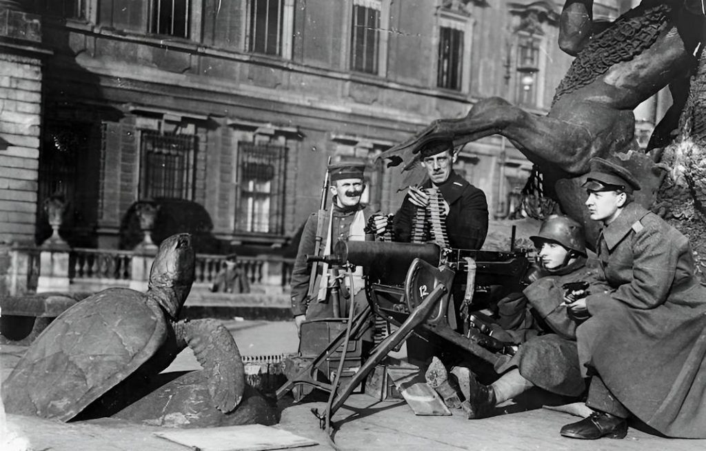 - Bundesarchiv Bild 146 2007 0005 Berlin Maschinengewehrposten am Schloss Brunnen 1 Poste de mitrailleuse au pied de la fontaine du château (Schloss-Brunnen), Berlin, novembre 1918 : la révolution qui emporte l'Empire ne se joue pas que dans les discours de balcon — elle se joue aussi, très concrètement, dans les rues de la capitale — Photo Bundesarchiv